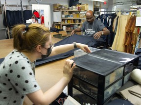 Parisa Zebardast (left) and Thavakumar Sellappah work on uniforms at Claymore Custom Clothiers Wednesday, September 21, 2022. Uniforms for first responder from across Canada are made by hand by a workforce that come from around the world at Claymore in Vancouver, BC.