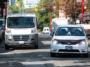 A motorists pulls into the oncoming lane to pass a stopped delivery van on East Georgia Street in Vancouver.