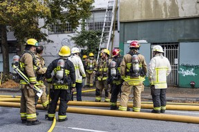 Gunmen attend a fire at the Sereenas Housing for Women unit on Powell Street in the Downtown Eastside on Saturday that left 50 residents homeless.