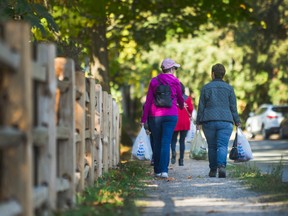 Two ladies carry bags of apples from the Apple Festival at UBC Botanical Gardens in Vancouver in 2017.