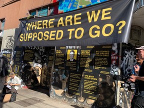 Posters plastered behind the podium outside the Balmoral Hotel in Vancouver for a Hastings Tent City news conference last month.