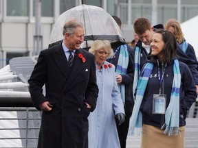 Prince Charles and Camilla, Duchess of Cornwall, walk over a bridge with Canadian athletes, including Karolina Wisniew (right) in the Olympic and Paralympic Village in Vancouver on November 7. (Arlen Redekop/PNG)