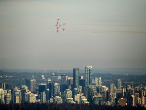 The Canadian Forces Snowbirds air demonstration team fly over the downtown skyline as part of the Celebration of Light fireworks festival, in Vancouver, on Wednesday, July 27, 2022.&ampnbsp;The Snowbirds have been cleared for take off after a crash in B.C. last month forced the military's famed aerobatics team to cancel appearances at several airshows.