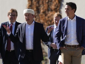 Squamish Nation councillor Khelsilem, front left, speaks with Prime Minister Justin Trudeau as they arrive for an announcement and groundbreaking at the First Nation’s Sen̓áḵw housing development site.