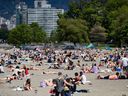 People sun themselves at Kitsilano Beach in Vancouver on Saturday, May 9, 2020. Twenty daily temperature records tumbled across British Columbia on Monday as conditions in the province remain unseasonably warm for the first week of fall.