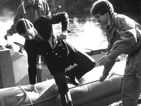 October 30, 1982: Prince Charles steps into water coming on float due to too many people — mostly media. Charles got his feet wet but avoided a dunking during his visit to Lester Pearson College. (Alex Barta/Victoria Times Colonist)