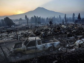 The sun rises over Mt. Shasta and homes destroyed by the Mill Fire on Saturday, Sept. 3, 2022, in Weed, Calif.
