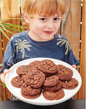 Fox holds a plate of Chocolate Chocolate Chip Cookies (aka Santa Cookies) from the cookbook Little Critics.