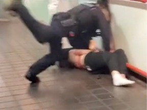 A Transit Police officer drives a knee into the back of a woman being arrested for a fourth time in a screen grab from video taken at the Granville SkyTrain Station in Vancouver on Oct. 27.