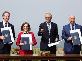 From left, California Gov. Gavin Newsom, Oregon Gov. Kate Brown, Washington Gov. Jay Inslee and B.C. Premier John Horgan hold up signed climate agreements during a press conference on Oct. 6 in San Francisco.