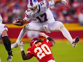 Josh Allen #17 of the Buffalo Bills hurdles over Justin Reid #20 of the Kansas City Chiefs during the fourth quarter at Arrowhead Stadium on October 16, 2022 in Kansas City, Missouri.