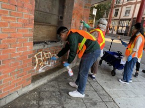 Volunteers work to clear graffiti on East Pender Street in Vancouver's Chinatown, Oct. 15, 2022. Photo: John Mackie, Postmedia