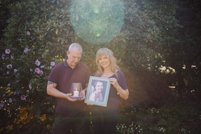 Hollie and Chris Hall holding a photo of their daughter Lily 