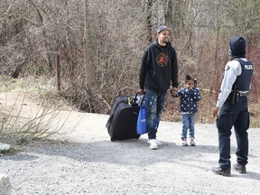 Asylum seekers cross into Canada from the U.S. border near a checkpoint on Roxham Road near Hemmingford, Quebec, Canada April 24, 2022.
