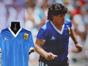 The football jersey worn by Argentina's Diego Maradona (pictured on the right during the 1986 World Cup quarter-final match against England) at Sotheby's auction house in London ahead of its sale in April 2022.