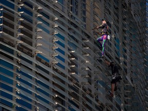 French skyscraper climber Alain Robert (L), known as the French Spiderman, climbs the Glorias Tower with his son Will in Barcelona on October 1, 2022. (Photo by Josep LAGO / AFP)
