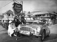 Restauranteur Frank Baker (L) and Mr. and Mrs. Sandy Luscombe-Whyte with the James Bond Aston Martin car in front of Baker's restaurant The Attic in  West Vancouver in 1969. Baker bought the car from Luscombe-Whyte and displayed it in front of his restaurant.  Story ran Province Nov 1969. Bill Cunningham/The Province