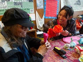 Volunteer CJ Santana, right, helps Darlene Ward make flower crowns for an altar for Day of the Dead on Nov. 2, to honour those who have been lost in the toxic drug crisis.