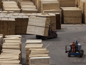 Machines move lumber ready for shipping at the West Fraser Timber Co. sawmill in Quesnel, British Columbia, Canada, on Friday, June 5, 2015.