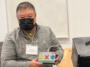 Henry Lee, Presiding Elections Officer for the City of Vancouver.  The machine Lee is demonstrating is called an ICE machine, which allows people to vote using their feet, mouth or by reading braille.  (Photo by Sarah Grochowski)