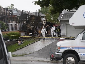 Investigators probe the site of a house fire on Wakefield Drive in Langley on June 15, 2020.