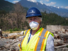 Denise O’Connor stands on the sidewalk in front of the remains of her home that burned down when a wildfire destroyed the village in 2021, in Lytton on Wednesday, June 15, 2022.