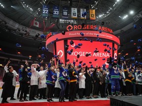 Rogers Arena employees throw hats into the air during an event where the Vancouver Canucks NHL hockey team announced an extension of their agreement with Rogers Communications and Sportsnet, in Vancouver, on Monday, October 31, 2022. The renewed partnership includes maintaining the naming rights of the arena and the broadcasting of games on Sportsnet through the 2032-33 season.