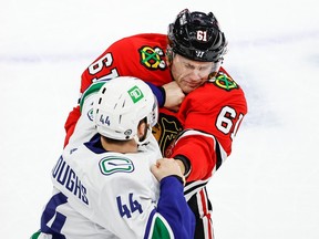 Vancouver Canucks defenseman Kyle Burroughs (44) fights with Chicago Blackhawks defenseman Riley Stillman (61) during the first period at United Center.