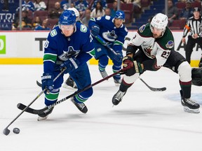 Arizona Coyotes forward Jack McBain (22) stick checks Vancouver Canucks forward Curtis Lazar (20) in the first period at Rogers Arena.