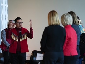 Squamish Nation councillor Khelsilem, left, raises his hands to incoming city councillors after presenting them with a copy of the United Nations Declaration on the Rights of Indigenous Peoples (UNDRIP) task force report, in Vancouver, on Wednesday, October 19, 2022. The final report is a result of a partnership with the Musqueam Indian Band, Squamish Nation and Tsleil-Waututh Nation. According to the task force it is the first co-developed strategy between Indigenous nations and a municipal government in Canada. THE CANADIAN PRESS/Darryl Dyck