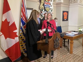 The newest member of the British Columbia legislature, Elenore Sturko (right), elected last month in Surrey South byelection, is sworn in by clerk Kate Ryan-Lord at the legislature in Victoria, Monday, Oct.3, 2022. The clerk says Sturko is the first politician pledging allegiance to King Charles.