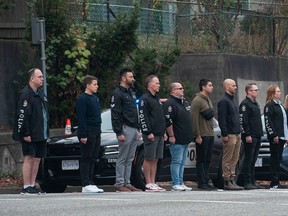 Police, emergency services personnel and the public line Grandview Highway in Vancouver on October 20, 2022.