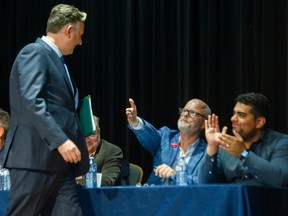 Progress Vancouver mayoral candidate Mark Marissen reaches out to Mayor Kennedy Stewart, as Progress Vancouver mayoral candidate Mauro Francis applaudes.