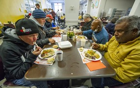 Steve Bryden (foreground left) enjoys Thanksgiving dinner with new and old acquaintances at the Union Gospel Mission in Vancouver on Monday. Photo: Arlen Redekop