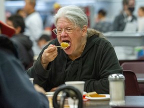 Sandra Stewart enjoys Thanksgiving dinner at the Union Gospel Mission in Vancouver on Monday. Photo: Arlen Redekop