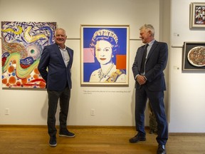 David and Robert Heffel stand next to Queen Elizabeth's Andy Warhol silkscreen prints at their galleries in Granville and 7th in Vancouver.