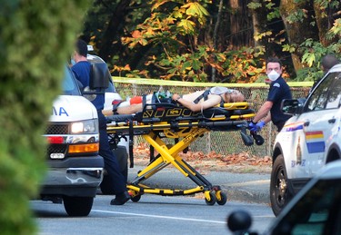 A victim is taken to an ambulance an incident on Canada Way in Burnaby, BC., on Oct. 18, 2022.