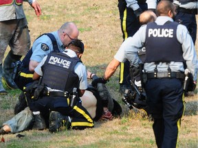 Burnaby RCMP handcuff a man after a police officer was stabbed on Tuesday morning.