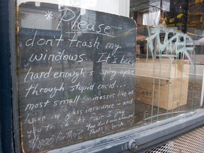 Sign in the window of Finch's Tea and Coffee House on October 18, 2021 in downtown Vancouver, urging people not to break their windows.