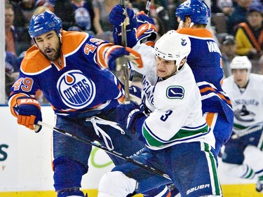 Edmonton Oilers Theo Peckham mixes it up with  Vancouver Canucks Kevin Bieksa during third period NHL action at Rexall Place in Edmonton, Alta., on Tuesday, April 5 2011.  The Oilers won 2-0.