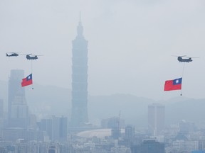 Chinook helicopters carrying Taiwan flags fly near the Taipei 101 skyscraper during the country's National Day celebration in Taipei, Taiwan October 10, 2022.