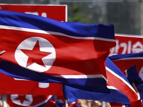 FILE - North Korean flags are carried during a celebration of the nation's 73rd founding anniversary in Pyongyang, North Korea on Sept. 9, 2021. The rival Koreas exchanged warning shots along their disputed western sea boundary on Oct. 24, 2022, their militaries said, amid heightened animosities over North Korea's recent barrage of weapons tests.