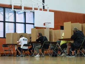 Voters mark their civic election ballots at a polling station in Vancouver, on Oct. 15, 2022.