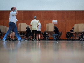 Voters mark their civic election ballots at a polling station in Vancouver, on Saturday, October 15, 2022.