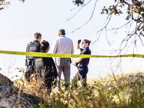 Saanich police investigate in the wooded area bordered by Saanich Road, Blanshard Street and the Pat Bay Highway near Uptown on Wednesday.