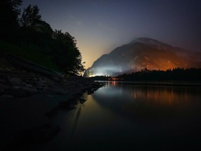 The Flood Falls Trail wildfire burns above the Fraser River in Hope, B.C., Monday, Sept. 12, 2022. As hot and dry conditions persist in the province, the superintendent of BC Wildfire Service's predictive services unit warns fire season in British Columbia is not yet over.