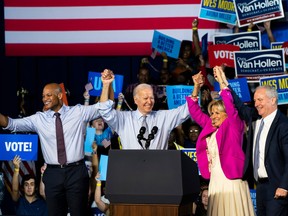 Democratic gubernatorial candidate Wes Moore (L) raises arms with President Joe Biden, first lady Jill Biden and U.S. Sen. Chris Van Hollen (D-MD) during a campaign rally at Bowie State University on November 7, 2022 in Bowie, Maryland. Moore faces Republican state Rep. Dan Cox in tomorrow's general election. (Photo by Nathan Howard/Getty Images)