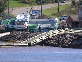 A lobster boat grounded on the rocks at the wharf in Stanley Bridge, P.E.I. on September 25, 2022 after post-tropical storm Fiona. Tides are rising, sands are shifting and coastlines are crumbling. As studies warn of rising seas and accelerated erosion resulting from climate change, coastal communities in Canada are wondering what the future holds.