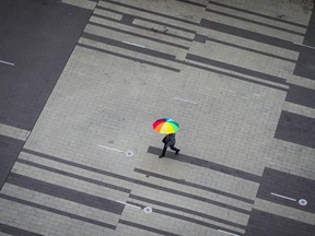 A pedestrian carries an umbrella as light rain falls in Surrey, B.C., on Friday, October 21, 2022. British Columbia's Sunshine Coast Regional District says continued "uncertainty" about water supplies means it will seek an extension of the state of local emergency declared last month.