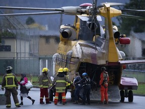 Search and rescue personnel help flood evacuees disembark from a helicopter in Agassiz, B.C. on Monday, Nov. 15, 2021.
